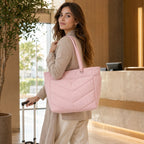 Pink Aria Quilted Padded Tote carried by a woman in a warm travel lounge setting