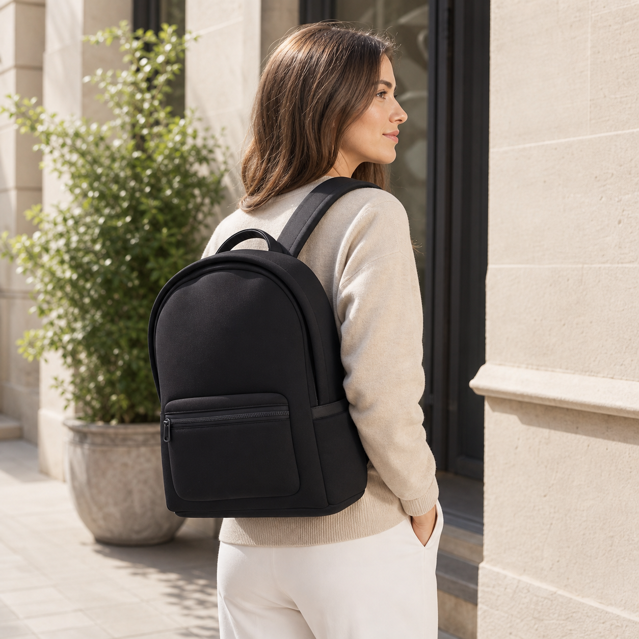 Serene black neoprene backpack styled on a woman for a polished work commute